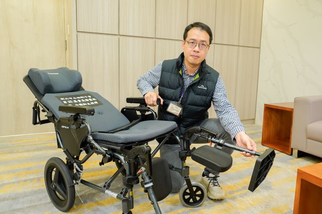 《圖說》新北市輔具資源中心物理治療師徐麒晏表示,獲贈的高背輪椅可無段式仰躺,還有撥腳腳靠,更可拆卸扶手直接移位,方便特殊身障者。〈社會局提供〉